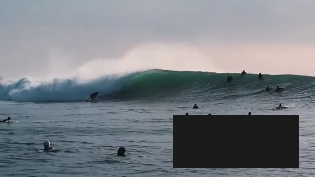 Video redaction example showing a solid black overlay covering part of a surfing scene